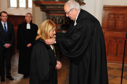 Bischof Michael Bünker überreicht der neuen Oberkirchenrätin Ingrid Bachler das Amtskreuz.
