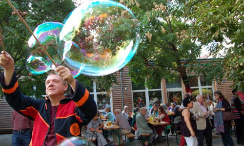 Seifenblasen und zusammensitzende Menschen sind zu sehen