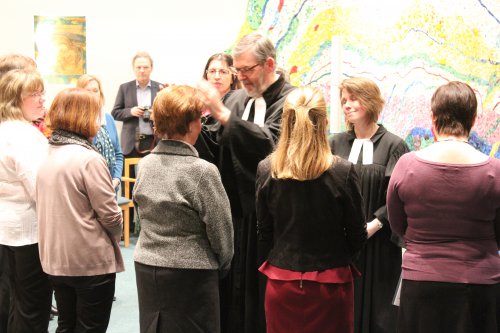 Superintendent Lein legt einer evangelischen Absolventin die Hände auf und segnet sie.