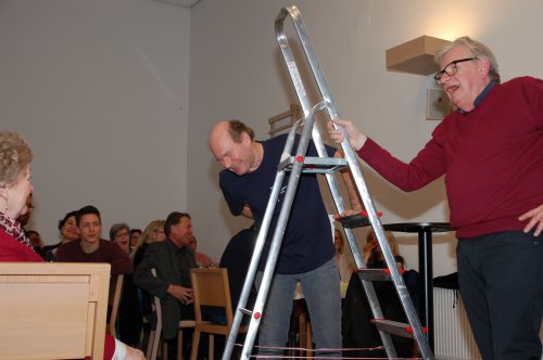 Schatzmeister und Kurator (rechts) müssen ein Banner für den Reformationstag an der Kirche anbringen