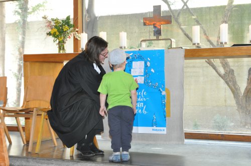 Viele Glieder, ein Leib: die Gottesdienstbesucher hefteten ihre Gaben an das Plakat am Altar