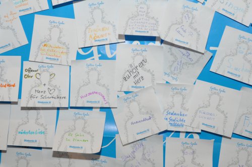 Viele Glieder, ein Leib: die Gottesdienstbesucher hefteten ihre Gaben an das Plakat am Altar