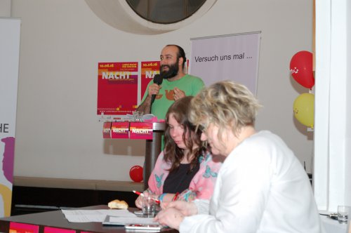 Osama slammt, während Hochschulpfarrerin Gerda Pfandl und Thyra Lang ein Blick auf die Uhr haben. Jeder hat nur 5 Minuten Zeit für seine Performance.