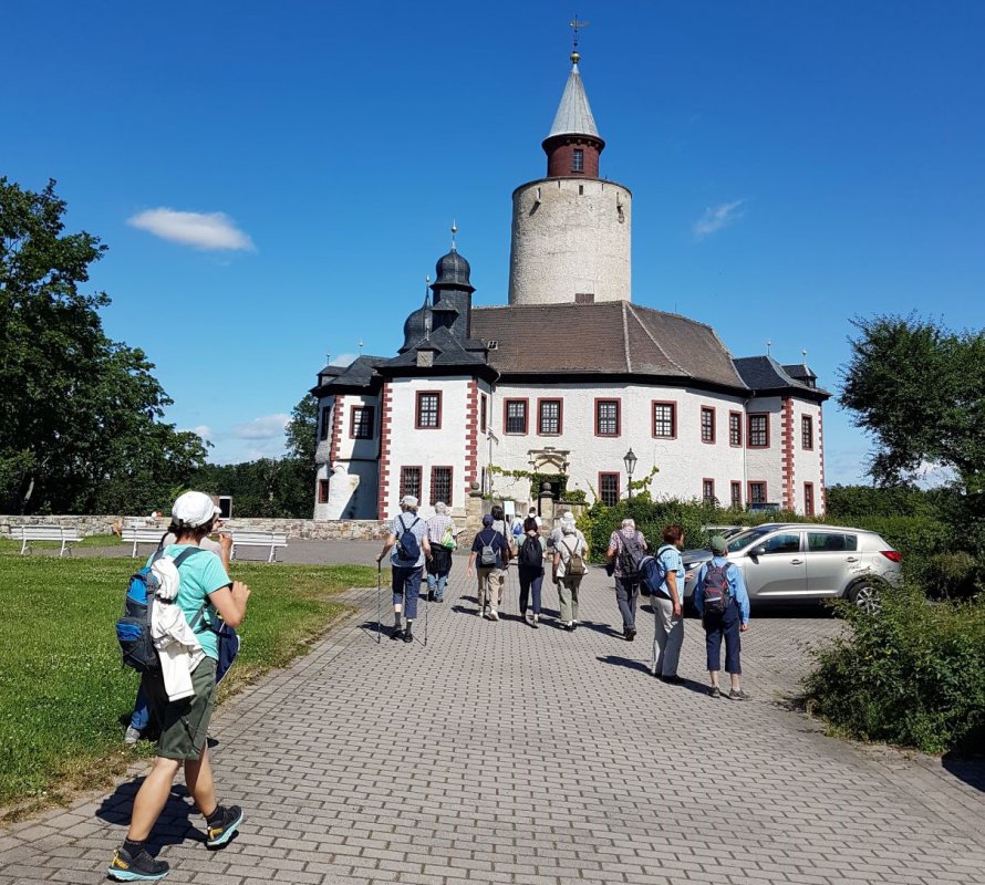 "Das Unterwegssein auf den verschiedenen Pilgerwegen hilft bei der Neuorientierung. Altes loslassen. Im Vertrauen auf Gott den neuen Weg gehen. So bekommt unser Leben einen wertvollen Impuls, der uns weiter voranträgt", so Arnhild Kump. Eine Gruppe von Pilgern gehen auf eine Kirche zu.