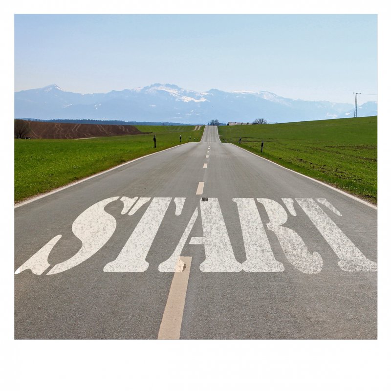 Lassen wir uns also ein auf das Wunder des Lebens, das im kleinen Anfang eines Lebensabschnitts immer eine Chance für uns parat hat. Das Wort "Start" steht auf einer Straße, die geradeaus führt. Die Landschaft ich hügelig, im Hintergrund sind Berge zu sehen.